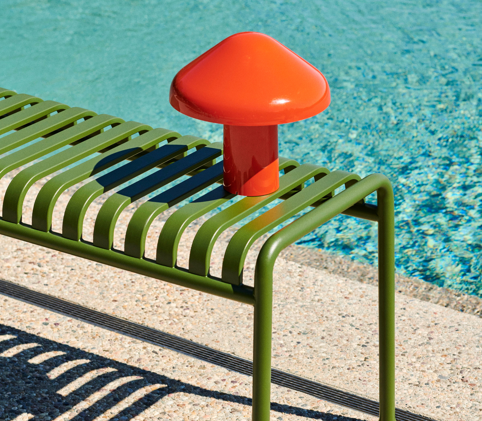 Pao Portable Lamp portátil de diseño en color rojo junto a una piscina